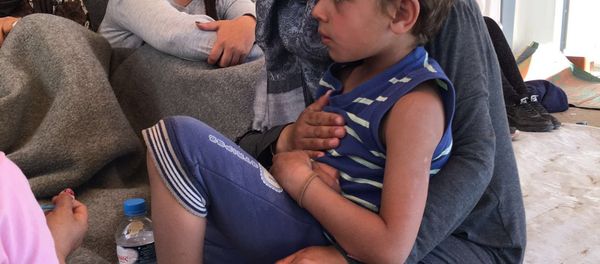 A woman holding a child at the refugee camp in Chios, Greece. A woman holding a child at the refugee camp in Chios, Greece. - Sputnik International