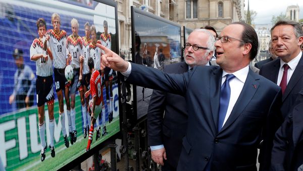 French President Francois Hollande (2ndL), flanked with French Soccer specialist Pierre Louis Basse (L), comment on a photo of Bulgarian soccer player Hristo Stoitchkov. - Sputnik International