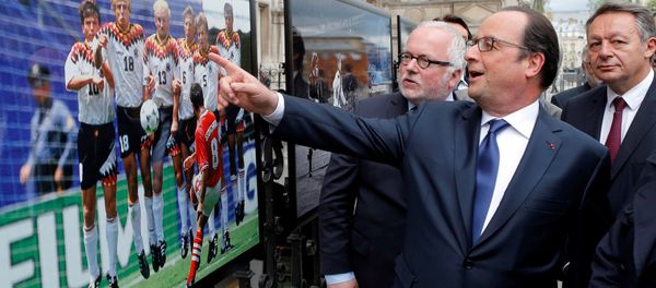 French President Francois Hollande (2ndL), flanked with French Soccer specialist Pierre Louis Basse (L), comment on a photo of Bulgarian soccer player Hristo Stoitchkov. - Sputnik International