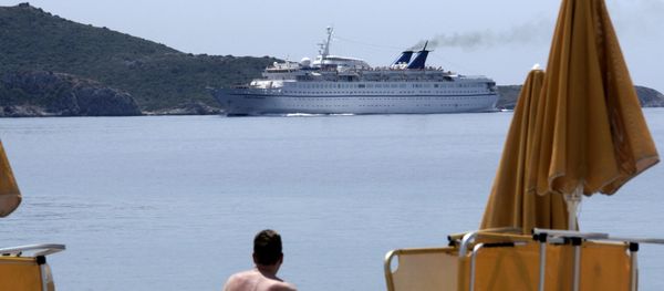 A vacationer at the island of Samos looks at the ferry Orient Queen passing along the coast - Sputnik International