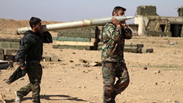 Soldiers from the Syrian army carry a rocket to fire at Daesh positions in the province of Raqqa, Syria - Sputnik International