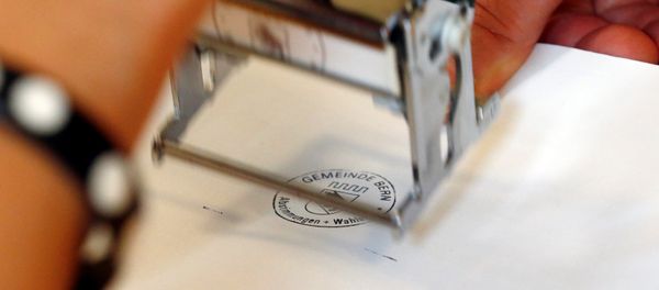 A ballot paper gets a stamp in a ballot office during a vote on whether to give every adult citizen a basic guaranteed monthly income of 2,500 Swiss francs ($2,560), in a school in Bern, Switzerland, June 5, 2016. A ballot paper gets a stamp in a ballot office during a vote on whether to give every adult citizen a basic guaranteed monthly income of 2,500 Swiss francs ($2,560), in a school in Bern, Switzerland, June 5, 2016. - Sputnik International