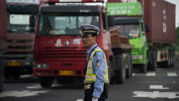 Policeman gestures in front of trucks, China Policeman gestures in front of trucks, China - Sputnik International