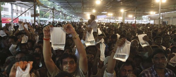Asthma patients display live fish they are carrying as they wait to receive special fish medicine which they hope will cure them in Hyderabad, India. - Sputnik International