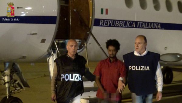 Medhanie Yehdego Mered (C), 35, is pictured with Italian policemen as they land at Palermo airport, Italy, following his arrest in Khartoum, Sudan, on May 24. - Sputnik International