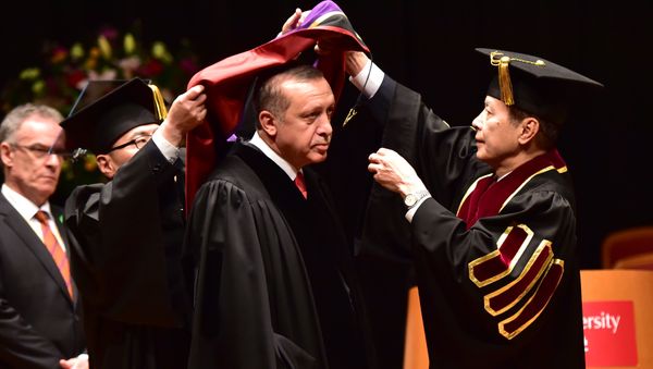 Turkish President Recep Tayyip Erdogan (C) wears an academic hood as he receives an honorary doctorate of laws from Waseda University president Kaoru Kamata (R) at the university in Tokyo on October 8, 2015 - Sputnik International