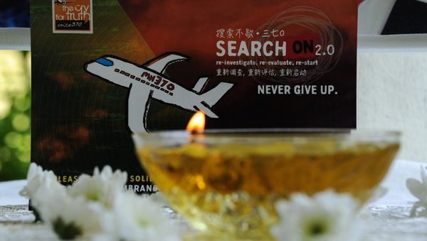 A candle burns a prayer message for passengers of missing Malaysia Airlines flight MH370 in Petaling Jaya on March 8, 2016 - Sputnik International