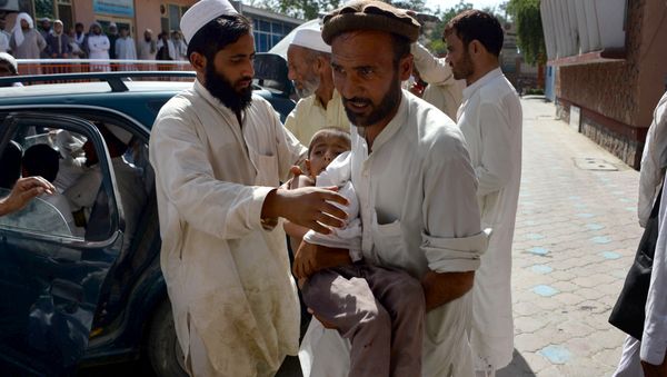 An Afghan volunteer carries a wounded child following an explosion inside a mosque in the Rodat district of Nangarhar province on June 10, 2016 An Afghan volunteer carries a wounded child following an explosion inside a mosque in the Rodat district of Nangarhar province on June 10, 2016 - Sputnik International