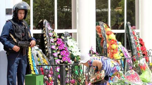 A woman places flowers outside the firearms shop, which was a target of a recent suspected Islamist militant attack, during the funeral of salesman Andrey Maksimenko in Aktobe, Kazakhstan, June 8, 2016 - Sputnik International