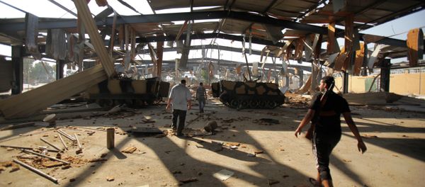 Libyan rebels walk at the Salaheddin army barracks bombed by NATO near Tripoli on August 27, 2011. - Sputnik International