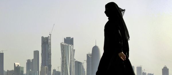 A Qatari woman walks in front of the city skyline in Doha, Qatar. A Qatari woman walks in front of the city skyline in Doha, Qatar. - Sputnik International