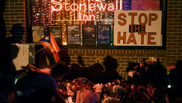 Shadows are cast on a wall as a man lights a candle at a memorial outside The Stonewall Inn on Christopher Street, considered by some as the center of New York State's gay rights movement, following the shooting massacre at Orlando's Pulse nightclub, in the Manhattan borough of New York, U.S., June 12, 2016. Shadows are cast on a wall as a man lights a candle at a memorial outside The Stonewall Inn on Christopher Street, considered by some as the center of New York State's gay rights movement, following the shooting massacre at Orlando's Pulse nightclub, in the Manhattan borough of New York, U.S., June 12, 2016. - Sputnik International