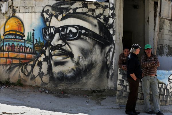 Palestinian refugees stand next to graffiti bearing a portrait of late Palestinian President Yasser Arafat at the Ain Al-Helweh refugee camp, near the southern Lebanese city of Sidon, on March 16, 2015 Palestinian refugees stand next to graffiti bearing a portrait of late Palestinian President Yasser Arafat at the Ain Al-Helweh refugee camp, near the southern Lebanese city of Sidon, on March 16, 2015 - Sputnik International