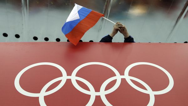 In this Feb. 18, 2014 file photo, a Russian skating fan holds the country's national flag over the Olympic rings before the start of the men's 10,000-meter speedskating race at Adler Arena Skating Center during the 2014 Winter Olympics in Sochi, Russia In this Feb. 18, 2014 file photo, a Russian skating fan holds the country's national flag over the Olympic rings before the start of the men's 10,000-meter speedskating race at Adler Arena Skating Center during the 2014 Winter Olympics in Sochi, Russia - Sputnik International