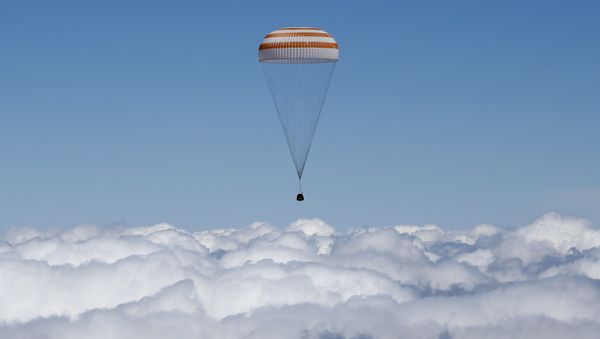 The Soyuz TMA-19M capsule carrying International Space Station (ISS) crew members, Tim Peake of Britain, Yuri Malenchenko of Russia and Tim Kopra of the U.S., descends beneath a parachute just before landing near the town of Zhezkazgan, Kazakhstan, on June 18, 2016 - Sputnik International