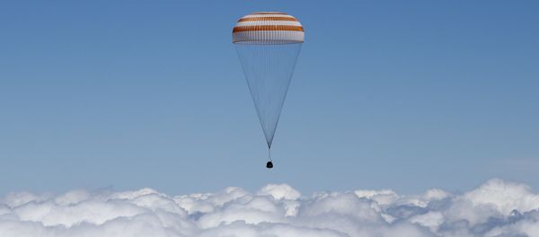 The Soyuz TMA-19M capsule carrying International Space Station (ISS) crew members, Tim Peake of Britain, Yuri Malenchenko of Russia and Tim Kopra of the U.S., descends beneath a parachute just before landing near the town of Zhezkazgan, Kazakhstan, on June 18, 2016 - Sputnik International