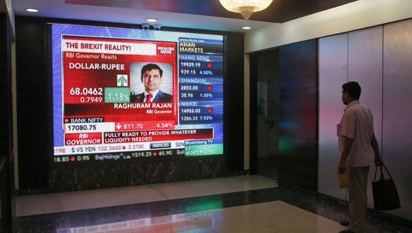 A man watches Reserve Bank of India governor Raghuram Rajan commenting on the situation after stock markets tumbled worldwide, on a stock markets indicator board in Mumbai, India, Friday, June 24, 2016. - Sputnik International
