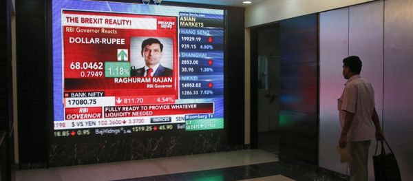 A man watches Reserve Bank of India governor Raghuram Rajan commenting on the situation after stock markets tumbled worldwide, on a stock markets indicator board in Mumbai, India, Friday, June 24, 2016. - Sputnik International
