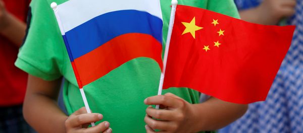 A child holds the national flags of Russia and China prior to a welcoming ceremony for Russian President Vladimir Putin outside the Great Hall of the People in Beijing, China, June 25, 2016 - Sputnik International