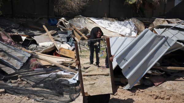 A woman from the Arab Jahalin Bedouin community carries a mirror after the demolition of her home in the West Bank Bedouin camp of al-Khan al-Ahmar on April 7, 2016 - Sputnik International