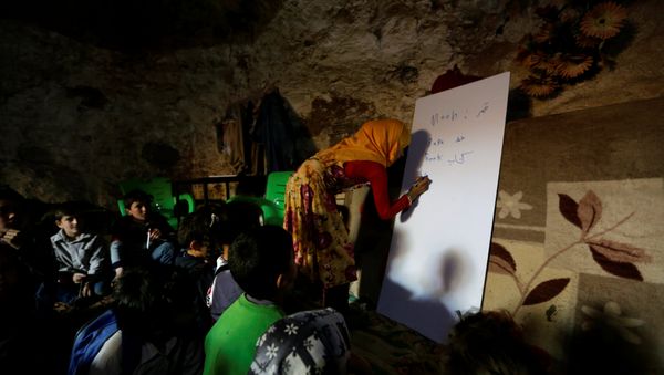 A teacher conducts a lesson for internally displaced children inside a cave in the rebel-controlled village of Tramla, in Idlib province, Syria March 27, 2016 A teacher conducts a lesson for internally displaced children inside a cave in the rebel-controlled village of Tramla, in Idlib province, Syria March 27, 2016 - Sputnik International