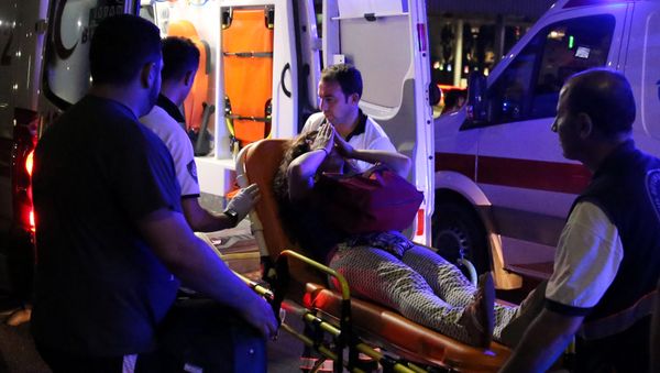 An injured woman covers her face as she is carried by paramedics into ambulance at Istanbul Ataturk airport, Turkey, following a blast June 28, 2016. - Sputnik International