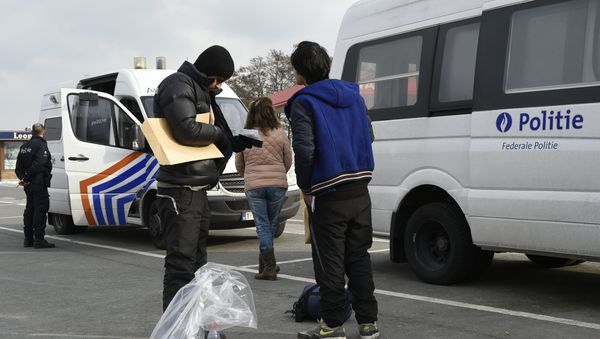 Migrants and  Belgian police officers near the Belgian-French border in Adinkerke. - Sputnik International