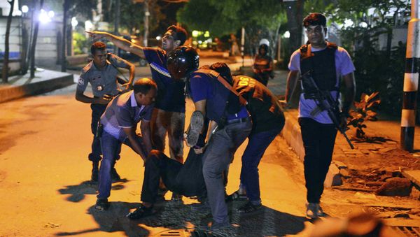 People help an unidentified injured person after a group of gunmen attacked a restaurant popular with foreigners in a diplomatic zone of the Bangladeshi capital Dhaka, Bangladesh, Friday, July 1, 2016. People help an unidentified injured person after a group of gunmen attacked a restaurant popular with foreigners in a diplomatic zone of the Bangladeshi capital Dhaka, Bangladesh, Friday, July 1, 2016. - Sputnik International