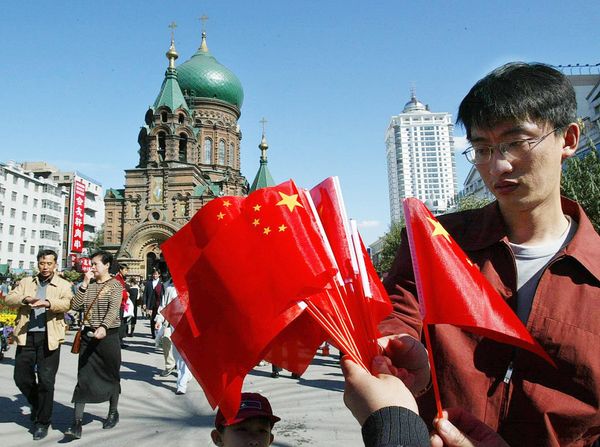 A man shops for flags in front of St. Sophie's Russian Orthodox Cathedral in Harbin, in northeast China's Heilongjiang province A man shops for flags in front of St. Sophie's Russian Orthodox Cathedral in Harbin, in northeast China's Heilongjiang province - Sputnik International