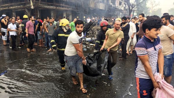 Iraqi firefighters and civilians carry bodies of victims killed in a car bomb at a commercial area in Karada neighborhood, Baghdad, Iraq, Sunday, July 3, 2016 Iraqi firefighters and civilians carry bodies of victims killed in a car bomb at a commercial area in Karada neighborhood, Baghdad, Iraq, Sunday, July 3, 2016 - Sputnik International