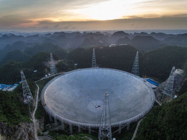 In this photo released by China's Xinhua News Agency, the sun sets above the Five-hundred-meter Aperture Spherical Telescope (FAST) in Pingtang County in southwestern China's Guizhou Province Monday, June 27, 2016 - Sputnik International