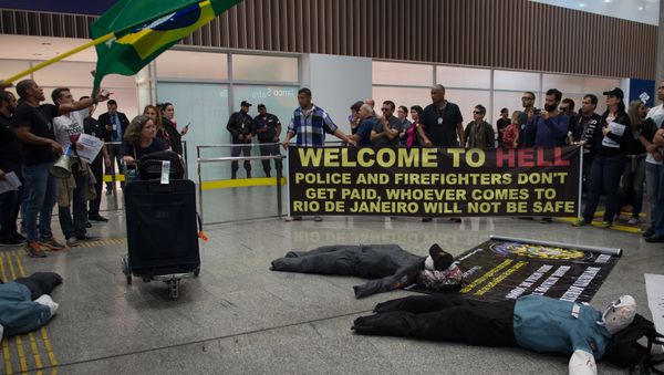 Police officers and firemen welcome passengers with a banner reading Welcome to Hell as they protest against the government for delay in their salary payments at Tom Jobim International Airport in Rio de Janeiro, Brazil, July 4, 2016 Police officers and firemen welcome passengers with a banner reading Welcome to Hell as they protest against the government for delay in their salary payments at Tom Jobim International Airport in Rio de Janeiro, Brazil, July 4, 2016 - Sputnik International