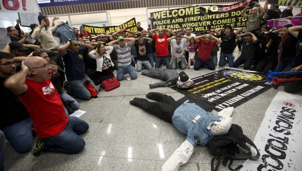 Police officers make a surrender position during a protest, demanding their payments and better labor conditions, at the Tom Jobim International Airport, in Rio de Janeiro, Brazil, Monday, July 4, 2016 Police officers make a surrender position during a protest, demanding their payments and better labor conditions, at the Tom Jobim International Airport, in Rio de Janeiro, Brazil, Monday, July 4, 2016 - Sputnik International
