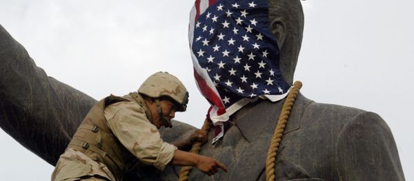 A US Marine covers the head of a statue of Iraqi President Saddam Hussein with the US flag before pulling it down in Baghdad's al-Fardous (paradise) square 09 April 2003 as the marines swept into the Iraqi capital and the Iraqi leader's regime collapsed. - Sputnik International