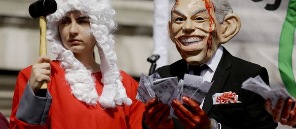 A protester wearing a former British Prime Minister Tony Blair mask, right, and another dressed as a judge pose for the media on a stage outside the Queen Elizabeth II Conference Centre in London, shortly before the publication of the Chilcot report into the Iraq war, Wednesday, July 6, 2016. A protester wearing a former British Prime Minister Tony Blair mask, right, and another dressed as a judge pose for the media on a stage outside the Queen Elizabeth II Conference Centre in London, shortly before the publication of the Chilcot report into the Iraq war, Wednesday, July 6, 2016. - Sputnik International