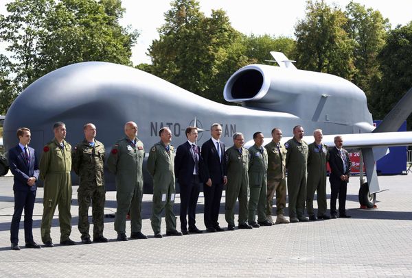 NATO Secretary-General Jens Stoltenberg (C) poses with officials and military personnel in front of a NATO unmanned drone outside PGE National Stadium, the venue of the NATO Summit, in Warsaw, Poland, July 8, 2016. - Sputnik International