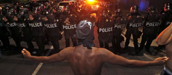 A protester raises him arms in front of a police blockade as marchers take to the streets to demonstrate against the recent fatal shootings of black men by police, Friday, July 8, 2016, in Phoenix. - Sputnik International