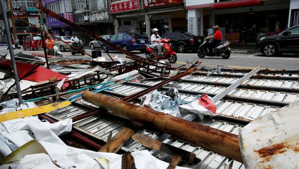 Motorcyclists ride past advertisement banners damaged by Typhoon Nepartak, in Taitung, Taiwan July 9, 2016 Motorcyclists ride past advertisement banners damaged by Typhoon Nepartak, in Taitung, Taiwan July 9, 2016 - Sputnik International