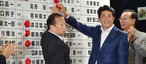 Japanese Prime Minister and ruling Liberal Democratic Party (LDP) president Shinzo Abe (C) places a red paper rosette on an LDP candidate's name to indicate an election victory at the party's headquarters in Tokyo on July 10, 2016 Japanese Prime Minister and ruling Liberal Democratic Party (LDP) president Shinzo Abe (C) places a red paper rosette on an LDP candidate's name to indicate an election victory at the party's headquarters in Tokyo on July 10, 2016 - Sputnik International