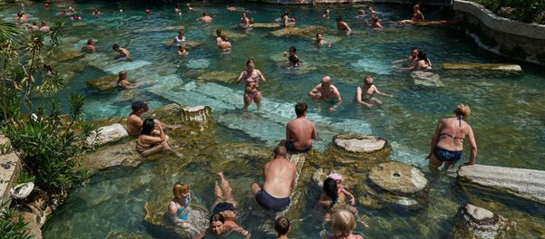 Tourists take a bath in a warm mineral water in the ancient city of Hierapolis built in the 2nd century BC and located 17 km off the city of Denizli, Turkey - Sputnik International