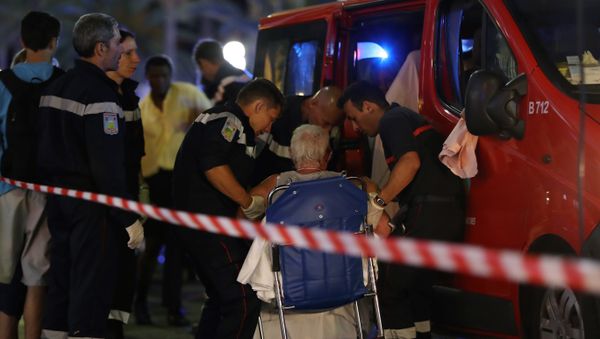 Rescue workers help an injured woman to get in a ambulance on July 15, 2016, after a truck drove into a crowd watching a fireworks display in the French Riviera town of Nice. - Sputnik International