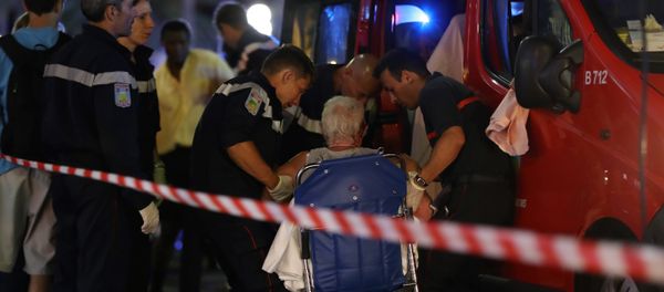 Rescue workers help an injured woman to get in a ambulance on July 15, 2016, after a truck drove into a crowd watching a fireworks display in the French Riviera town of Nice. - Sputnik International
