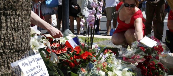 A woman places a bouquet of flowers as people pay tribute near the scene where a truck ran into a crowd at high speed killing scores and injuring more who were celebrating the Bastille Day national holiday, in Nice, France, July 15, 2016. A woman places a bouquet of flowers as people pay tribute near the scene where a truck ran into a crowd at high speed killing scores and injuring more who were celebrating the Bastille Day national holiday, in Nice, France, July 15, 2016. - Sputnik International