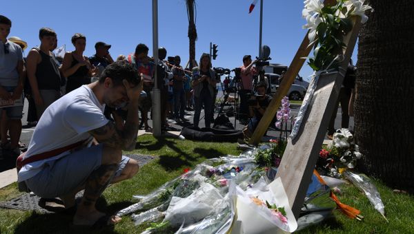 A man kneels and holds his head on July 15, 2016 in front of flowers placed near the site in Nice where a gunman smashed a truck into a crowd of revellers celebrating Bastille Day, killing at least 84 people. - Sputnik International