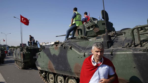 A man wrapped in a Turkish flag stands next to military vehicles in front of Sabiha Airport, in Istanbul, Turkey July 16, 2016. A man wrapped in a Turkish flag stands next to military vehicles in front of Sabiha Airport, in Istanbul, Turkey July 16, 2016. - Sputnik International