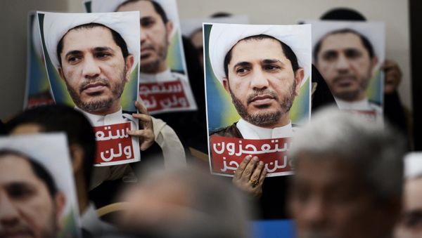 Bahraini men hold placards bearing the portrait of Sheikh Ali Salman, head of the Shiite opposition movement Al-Wefaq, during a protest on May 29, 2016 against his arrest, at Al wefaq headquarter building, in the village of Zinj on the outskirts of the capital Manama. - Sputnik International