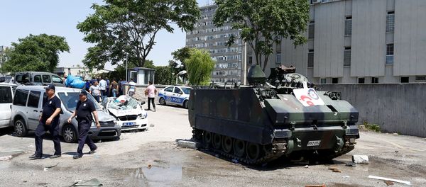 Damaged cars are seen next to an armored military vehicle in front of the police headquarters in Ankara, Turkey, July 18, 2016. - Sputnik International