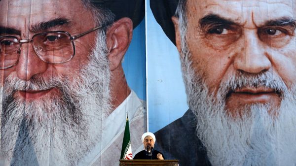 Iranian President Hassan Rouhani delivers a speech under portraits of Iran's supreme leader, Ayatollah Ali Khamenei (L) and Iran's founder of the Islamic Republic, Ayatollah Ruhollah Khomeini (R), on the eve of the 25th anniversary of the Islamic revolutionary leader Ayatollah Ruhollah Khomeini's death, at his mausoleum in a suburb of Tehran  - Sputnik International