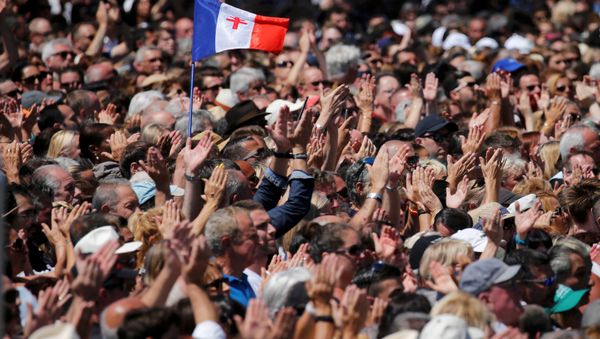 A French flag flies among the crowd as people applaud in front of the Monument du Centenaire during a minute of silence on the third day of national mourning to pay tribute to victims of the truck attack along the Promenade des Anglais on Bastille Day that killed scores and injured as many in Nice, France, July 18, 2016. A French flag flies among the crowd as people applaud in front of the Monument du Centenaire during a minute of silence on the third day of national mourning to pay tribute to victims of the truck attack along the Promenade des Anglais on Bastille Day that killed scores and injured as many in Nice, France, July 18, 2016. - Sputnik International