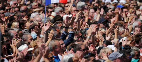A French flag flies among the crowd as people applaud in front of the Monument du Centenaire during a minute of silence on the third day of national mourning to pay tribute to victims of the truck attack along the Promenade des Anglais on Bastille Day that killed scores and injured as many in Nice, France, July 18, 2016. A French flag flies among the crowd as people applaud in front of the Monument du Centenaire during a minute of silence on the third day of national mourning to pay tribute to victims of the truck attack along the Promenade des Anglais on Bastille Day that killed scores and injured as many in Nice, France, July 18, 2016. - Sputnik International